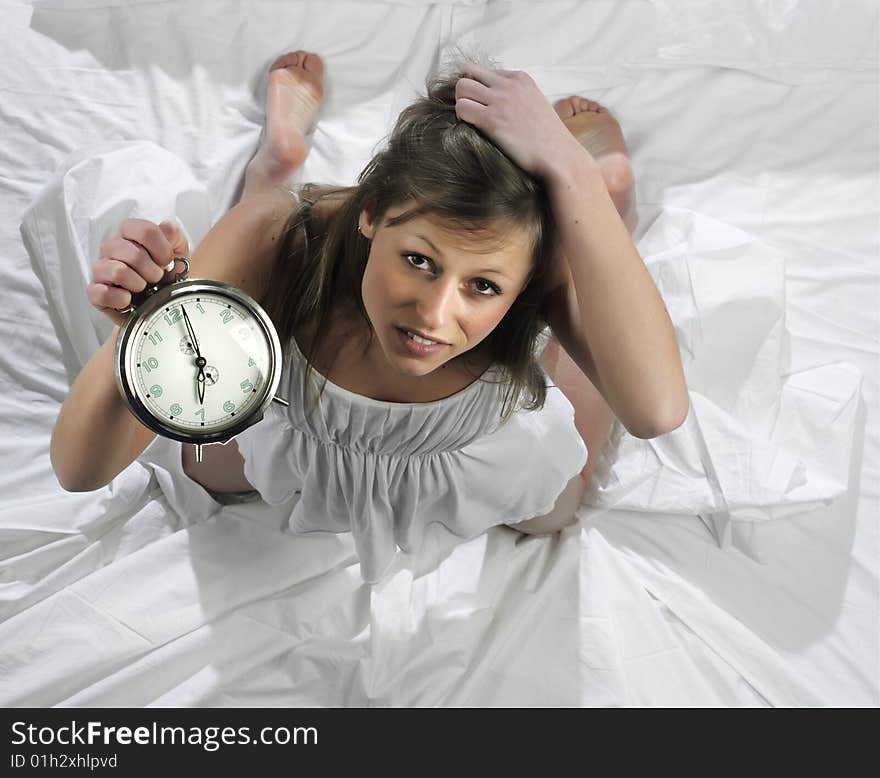 Woman in bed with alarm clock