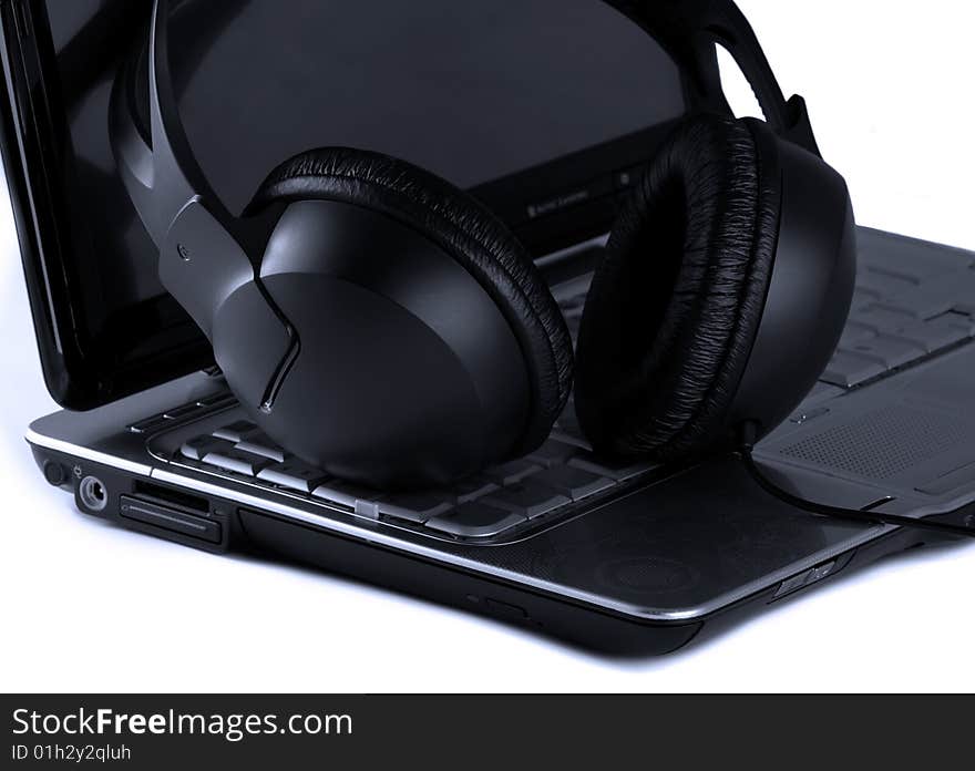 Close up of laptop and headphones on white background