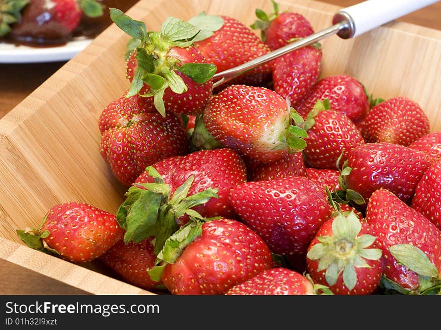 Fresh juicy strawberries in a wooden bowl with a serving utensil  copy space