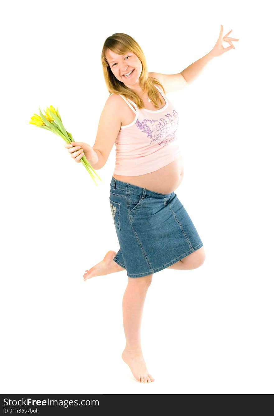 Pregnant woman dancing with yellow tulips on white background