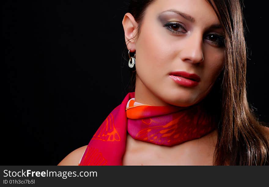 Beautiful brunet woman in red scarf at black background. Beautiful brunet woman in red scarf at black background