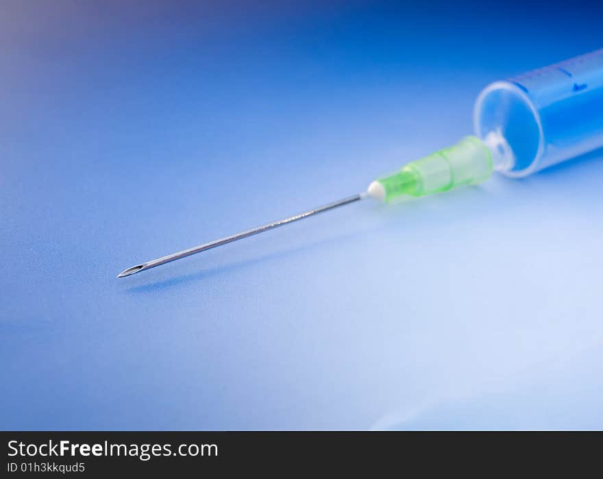 Empty syringe on blue background