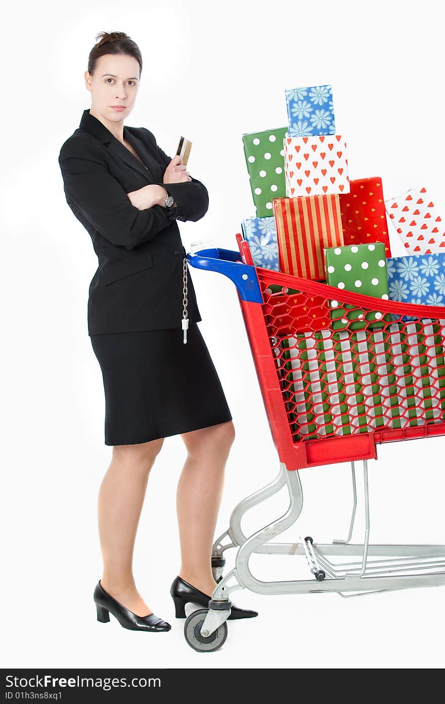 A smartly dressed woman shopping for gifts with a credit card and shopping cart on white. A smartly dressed woman shopping for gifts with a credit card and shopping cart on white.