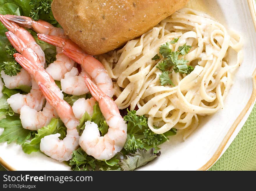 Boiled shrimp salad with fettuccini alfredo and Italian bread with copy space. Boiled shrimp salad with fettuccini alfredo and Italian bread with copy space