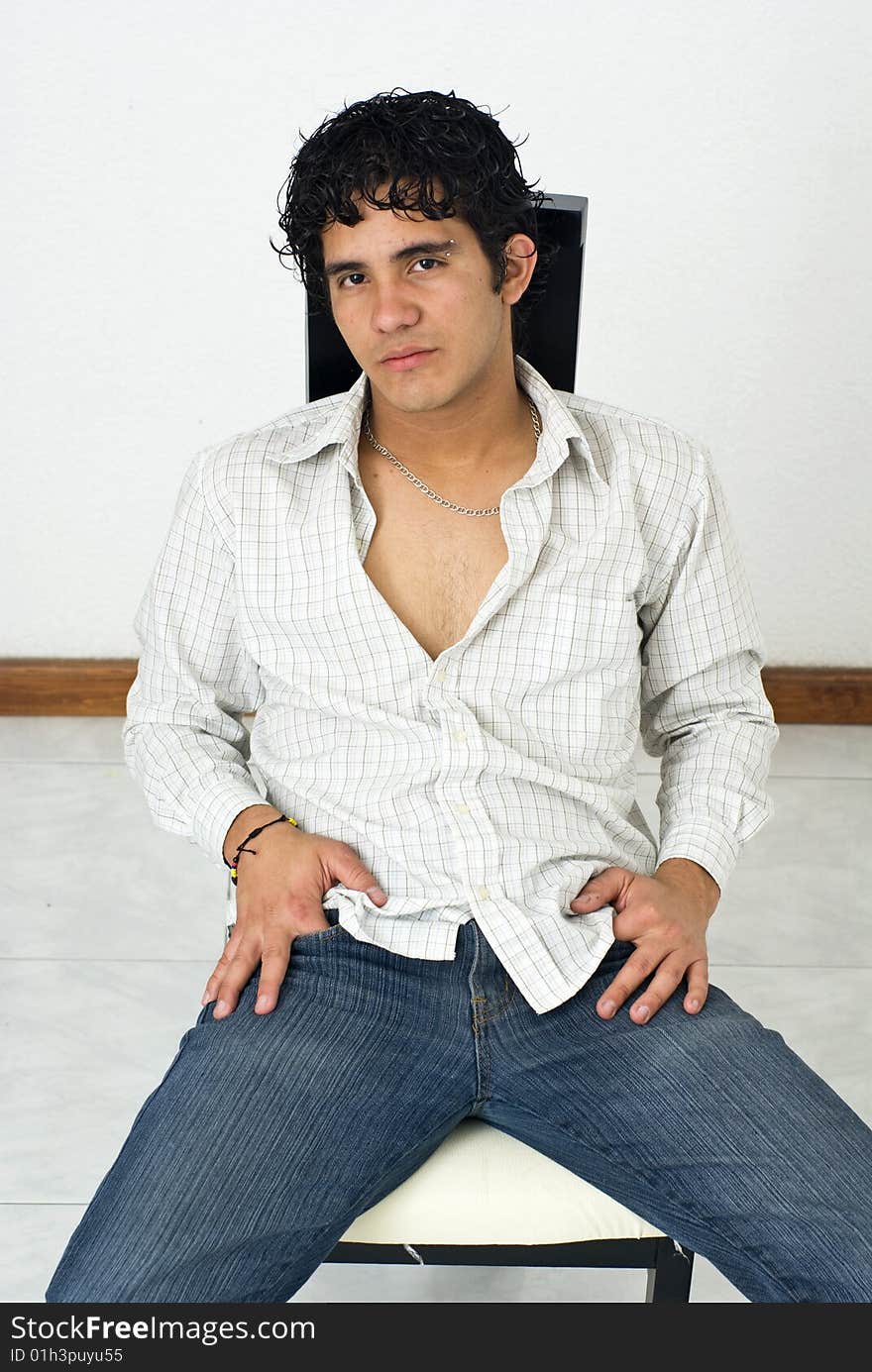 Teenager latino boy seated posing to the camera. Teenager latino boy seated posing to the camera