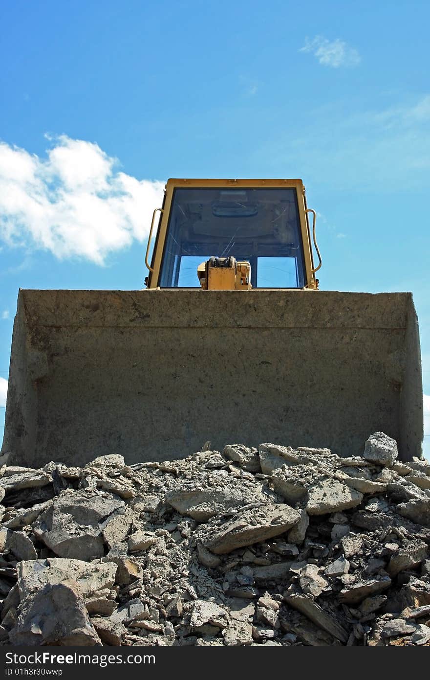 Large bulldozer working on a empty lot moving rock around