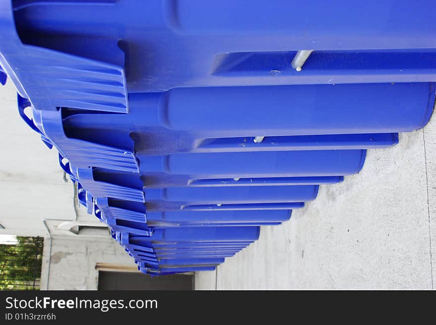 Row of big blue recycling bins