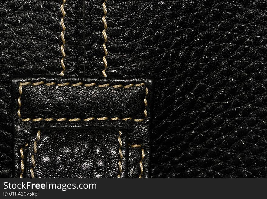 Black leather macro texture with light thread