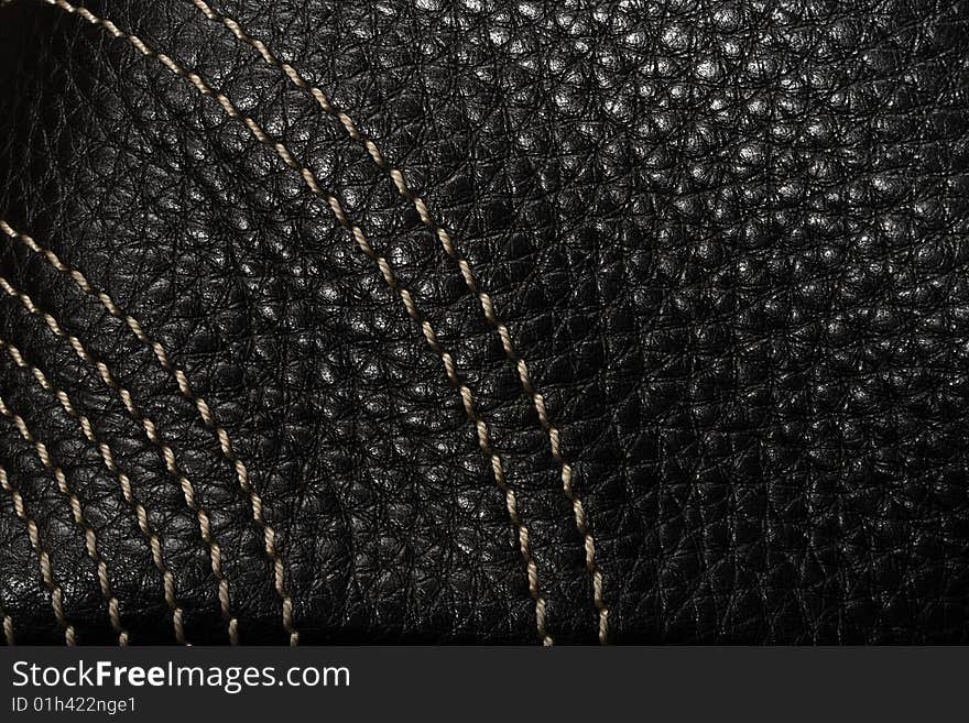 Black leather macro texture with light thread