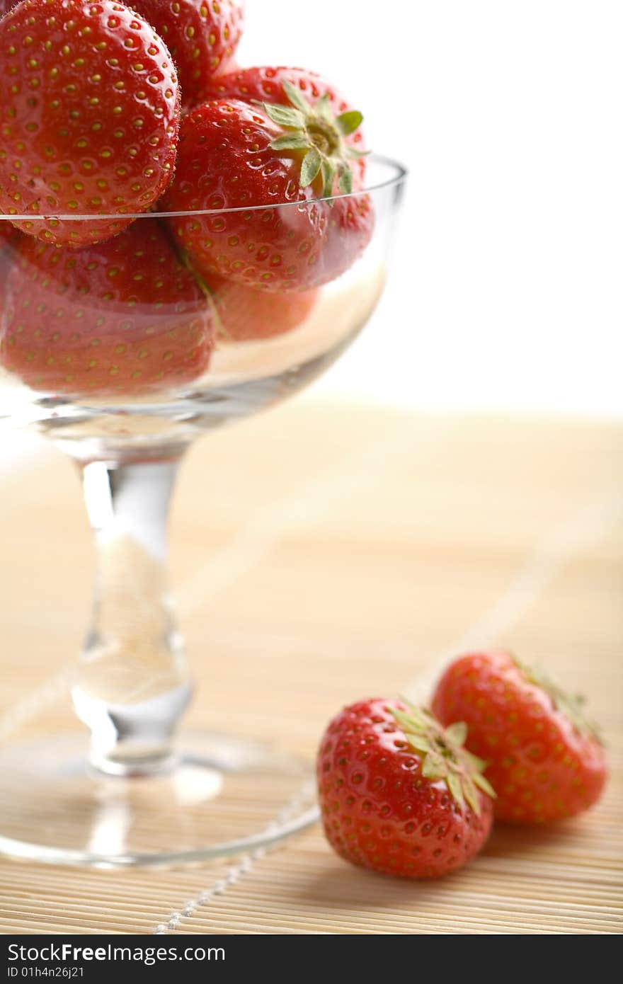 Ripe strawberries in glass bowl isolated