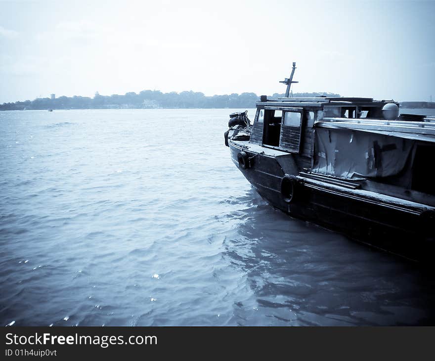 A old fishing boat from Ubin island going towards Singapore in selenium tone