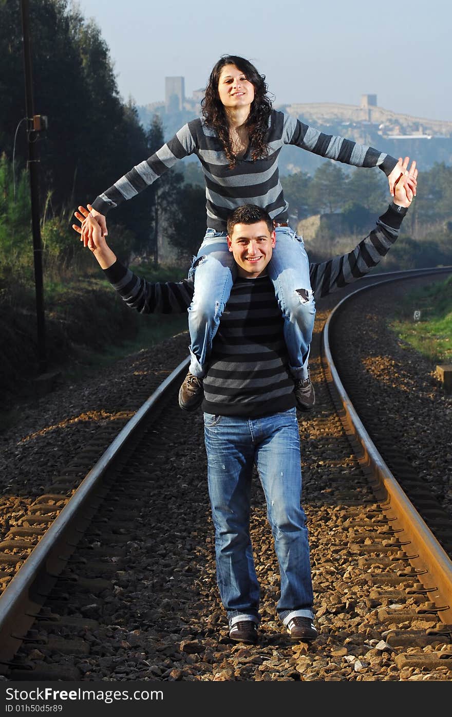 Young couple walking on railway tracks