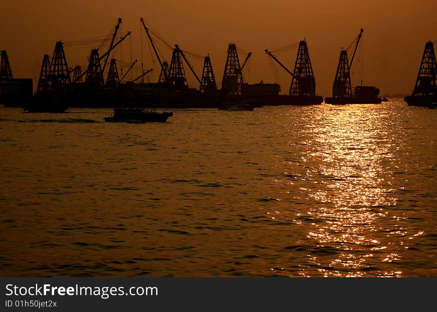 Cargo port with industrial cranes against sunset sky. Cargo port with industrial cranes against sunset sky