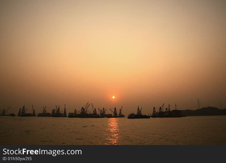 Cargo port with industrial cranes against sunset sky. Cargo port with industrial cranes against sunset sky