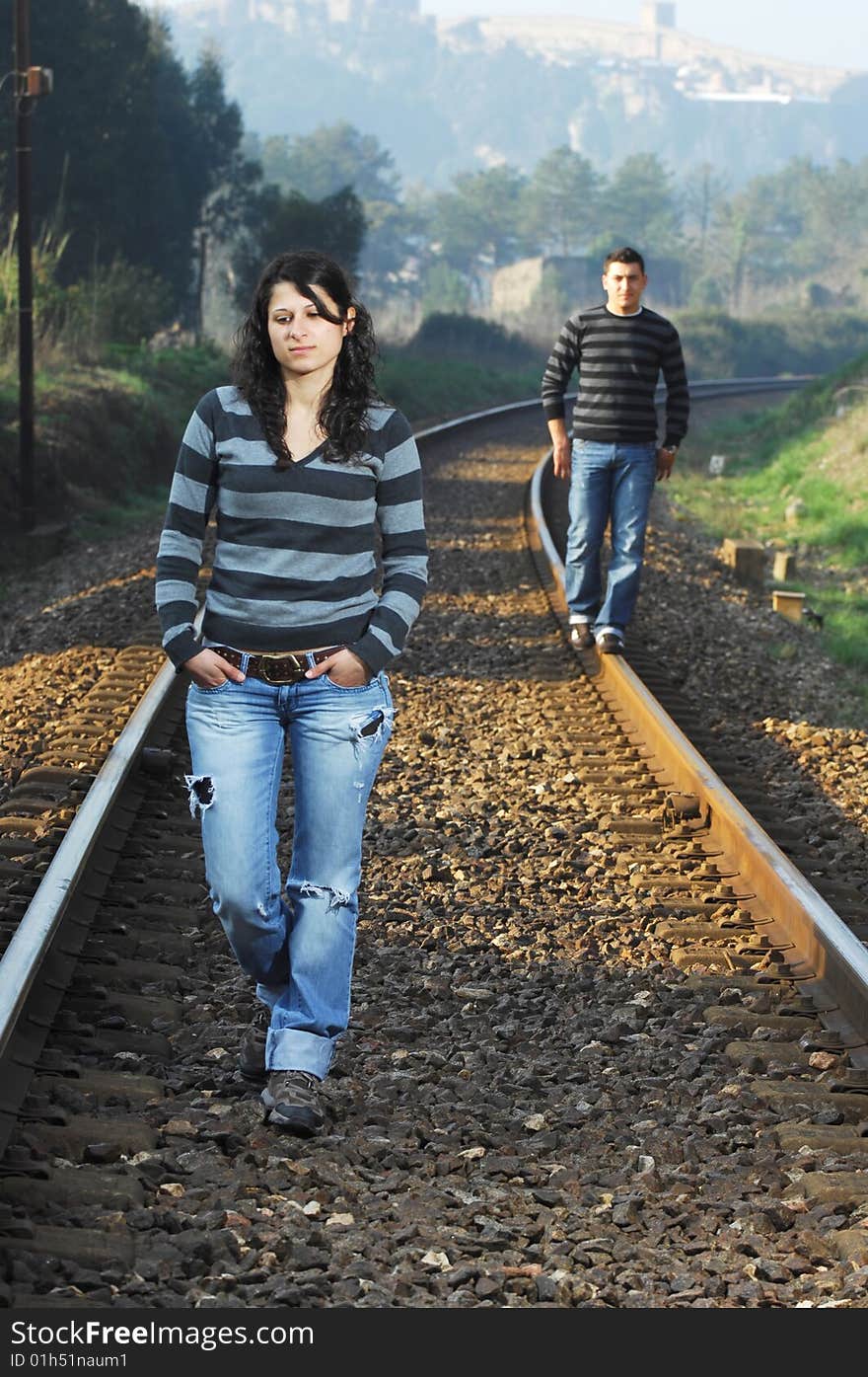 Young couple walking on railway tracks