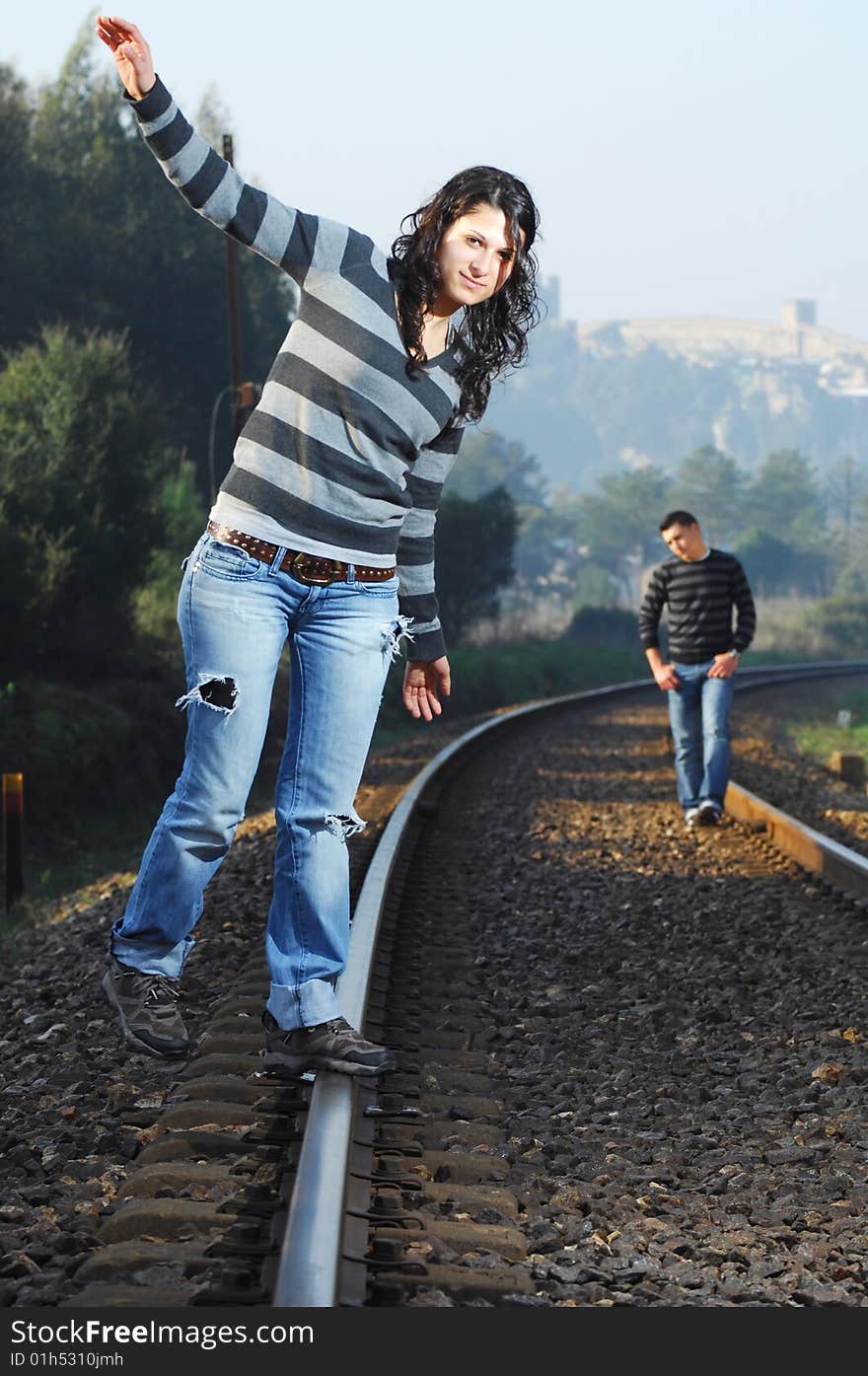 Young couple walking on railway tracks