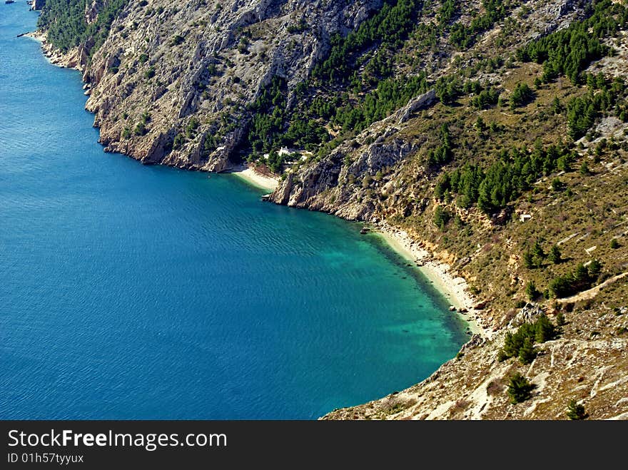 Deserted sand beach under a steep hill on a sunny autumn afternoon. Deserted sand beach under a steep hill on a sunny autumn afternoon.