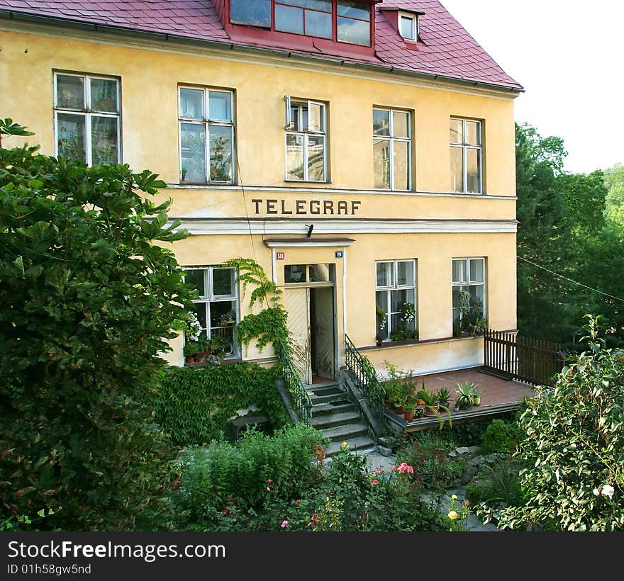 Provincial telegraph building in green yard with flowers