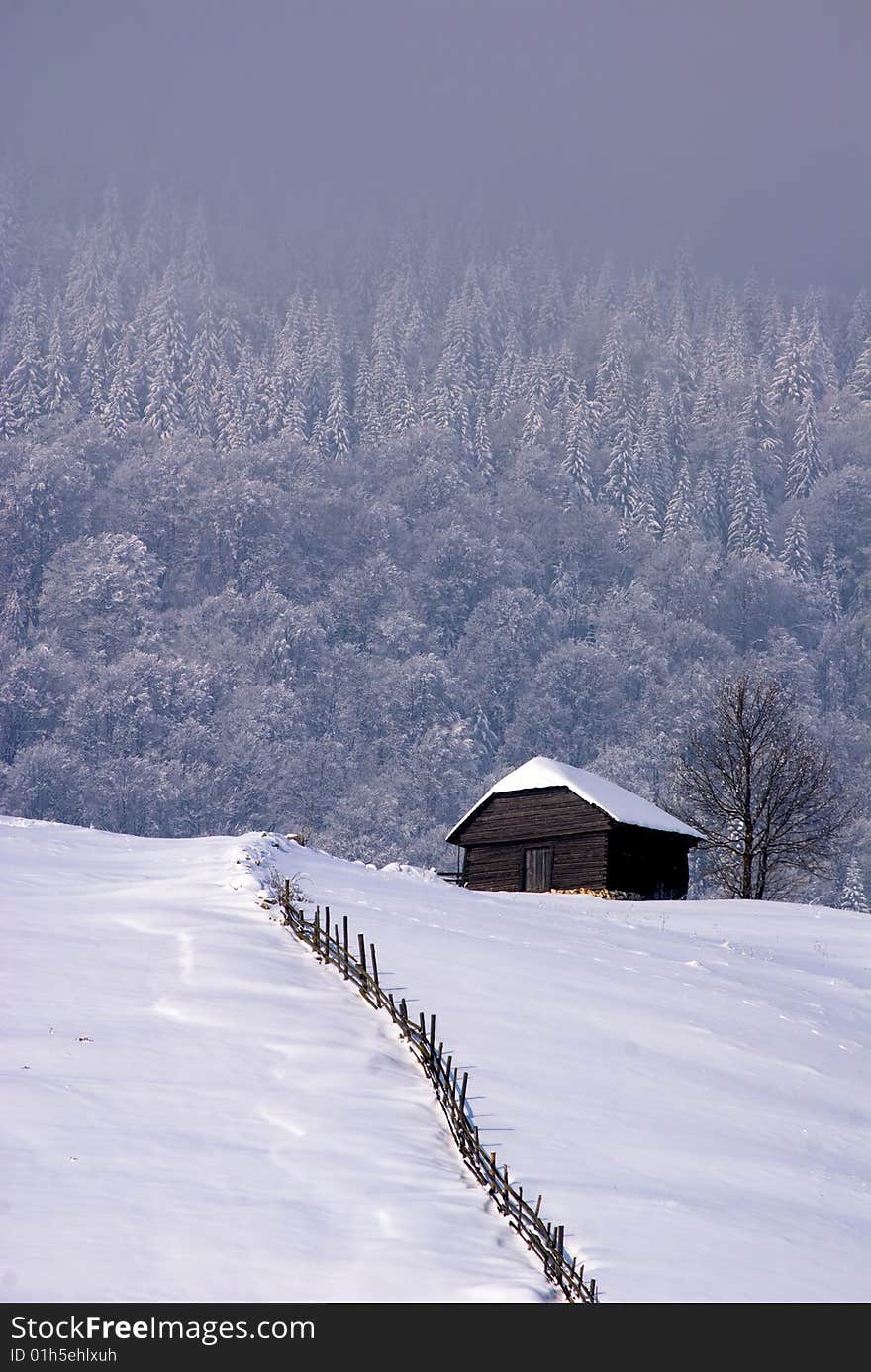 Winter landscape;Lonley house in a village in the mountains,in Romania. Winter landscape;Lonley house in a village in the mountains,in Romania