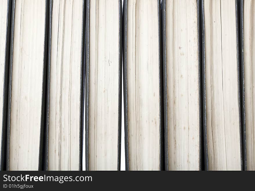 Close-up of a row of old marked antique books, leather-bound with white background light through the gaps between books. Close-up of a row of old marked antique books, leather-bound with white background light through the gaps between books