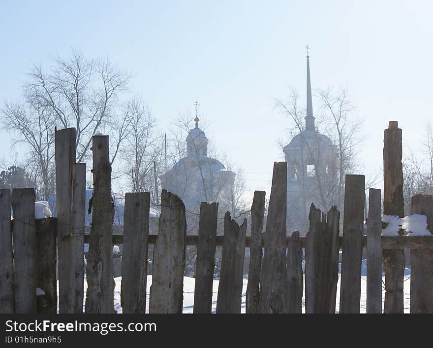 View of church of 17 century behind the old fence. View of church of 17 century behind the old fence.