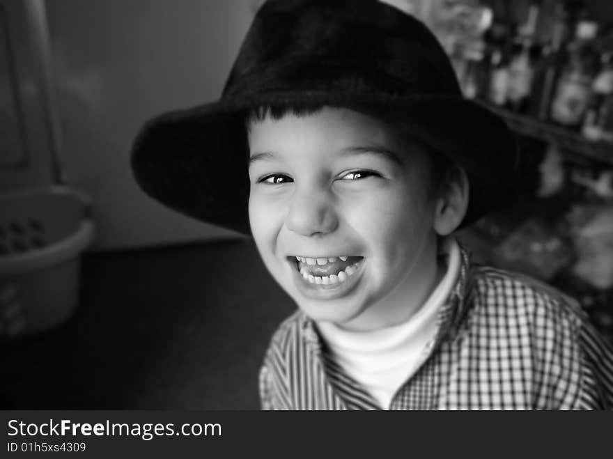 A three-year-old plays with an old hat. Shallow depth of field. A three-year-old plays with an old hat. Shallow depth of field.