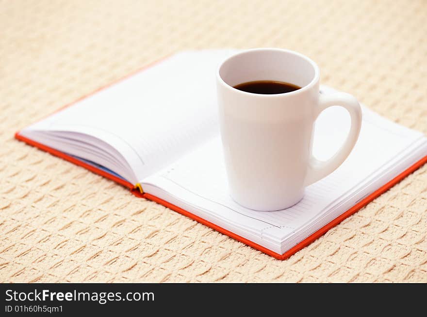 Cup of coffee and an opened organizer. Cup of coffee and an opened organizer