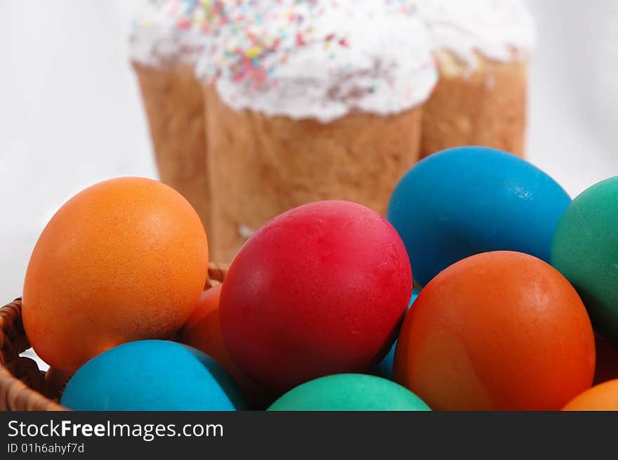 Colored easter eggs on a white background with Kulich