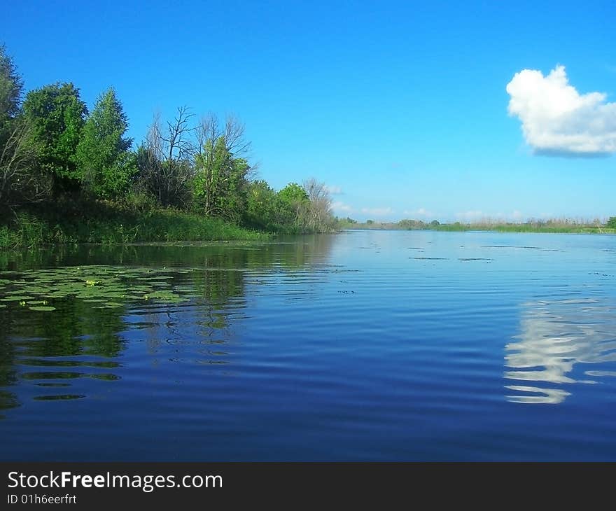 Pond with clear blue water and land. Pond with clear blue water and land