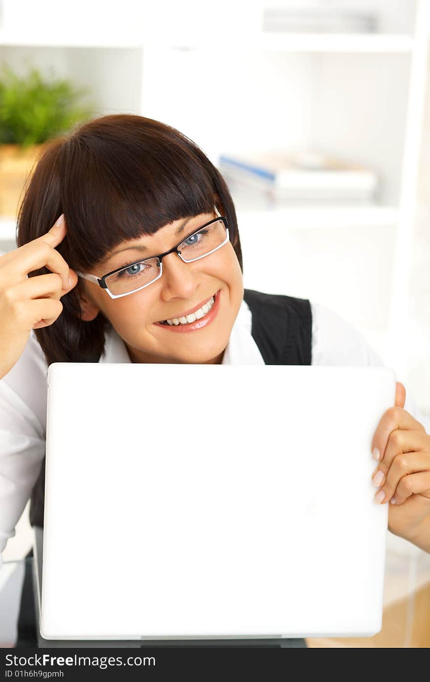 Beautiful business woman sitting at the desk in office. Beautiful business woman sitting at the desk in office