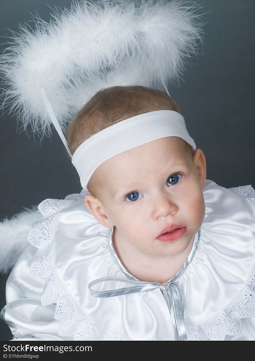 Baby angel girl with nimbus and fluffy wings looking up