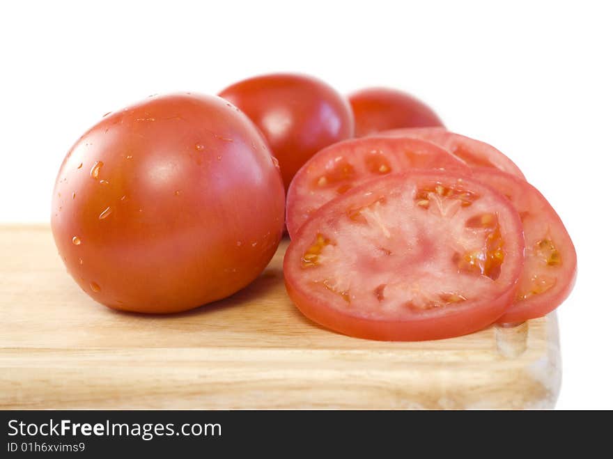 Fresh sliced tomatoes on a cutting board with white background and copy space. Fresh sliced tomatoes on a cutting board with white background and copy space