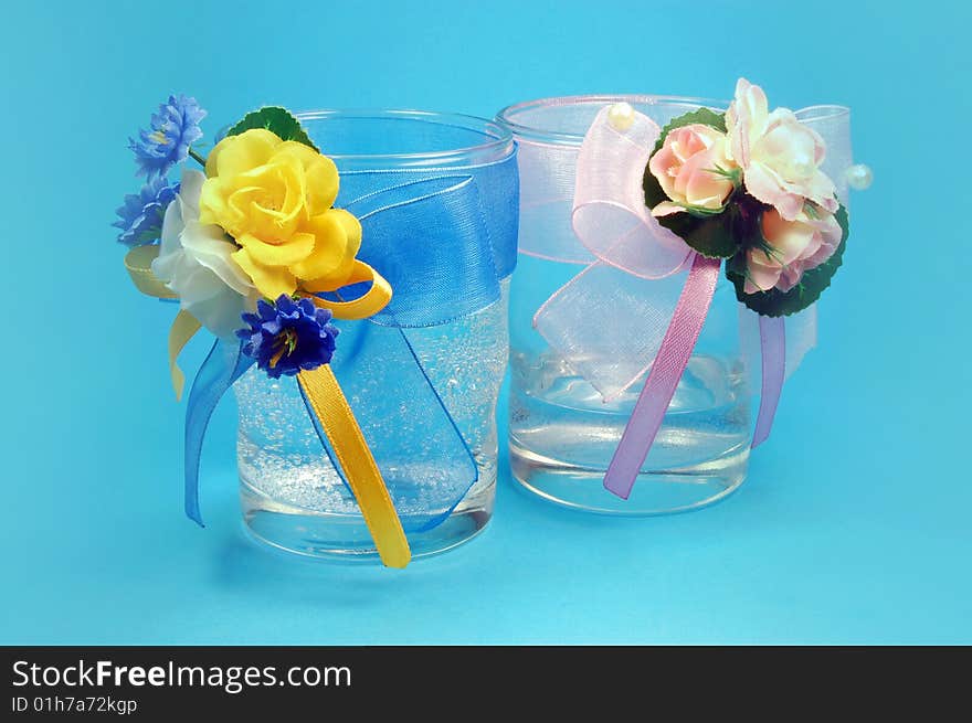 Glasses with flowers isolated on blue