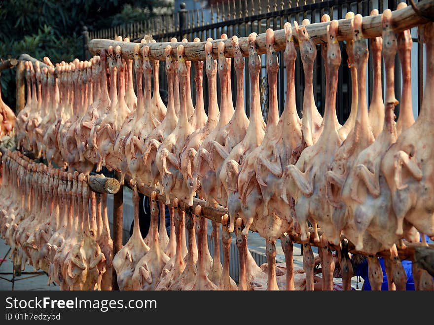 Hundreds of dried, pressed ducks hang from bamboo poles outside a meat market and are offered for sale, most especially during the Chinese Lunar New Year holiday - Lee Snider Photo. Hundreds of dried, pressed ducks hang from bamboo poles outside a meat market and are offered for sale, most especially during the Chinese Lunar New Year holiday - Lee Snider Photo.