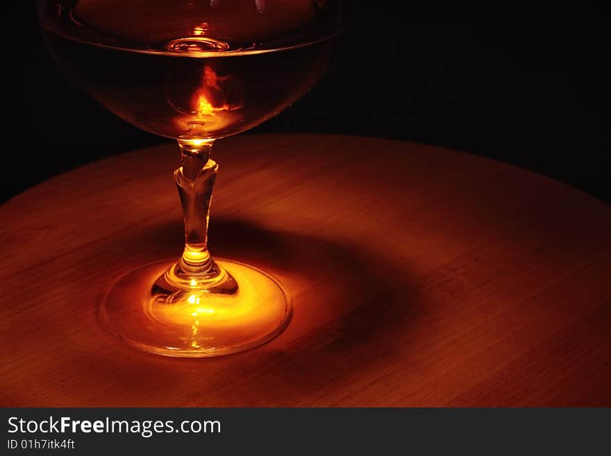 Brandy in glass on a wooden table