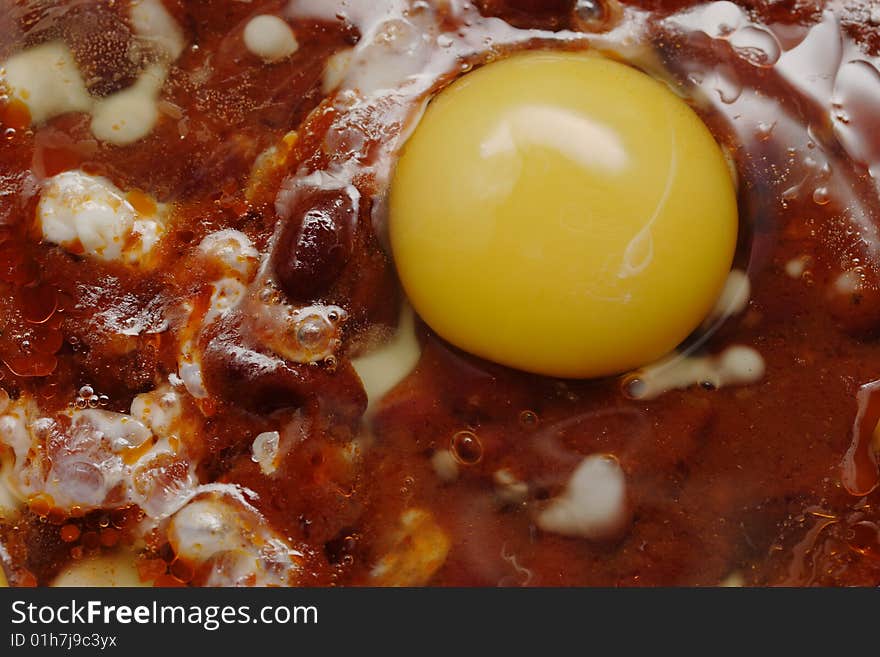 Eggs and red beans in the chili sauce fry on the skillet. Narrow depth of field. Eggs and red beans in the chili sauce fry on the skillet. Narrow depth of field.