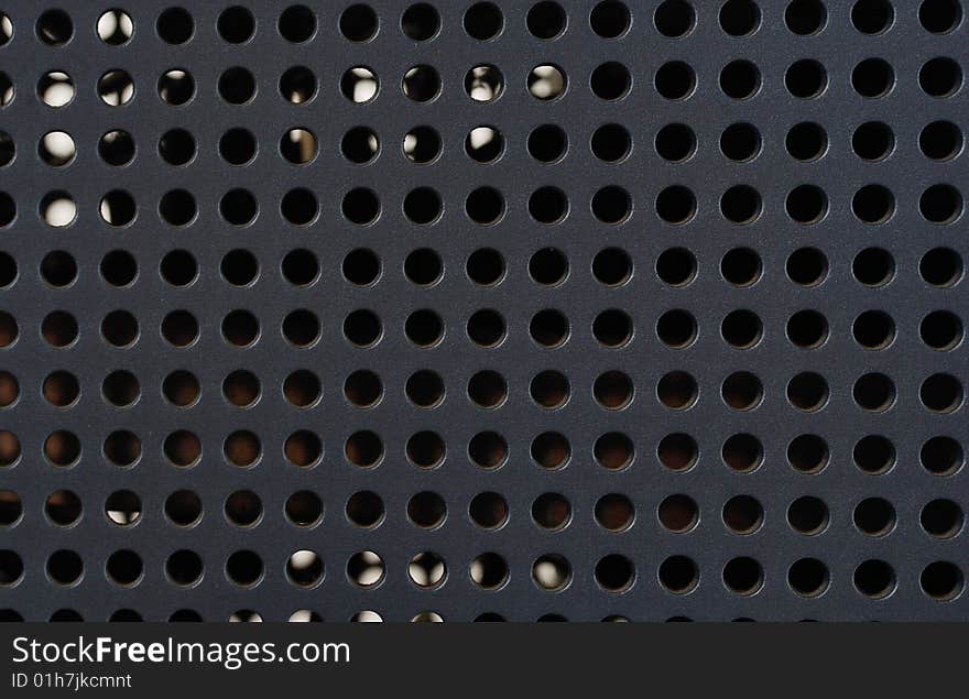 Plastic grille with round holes on the black background. Plastic grille with round holes on the black background.