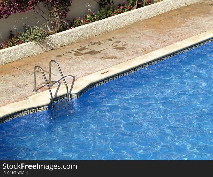 Swimming pool entrance with metal hand rail