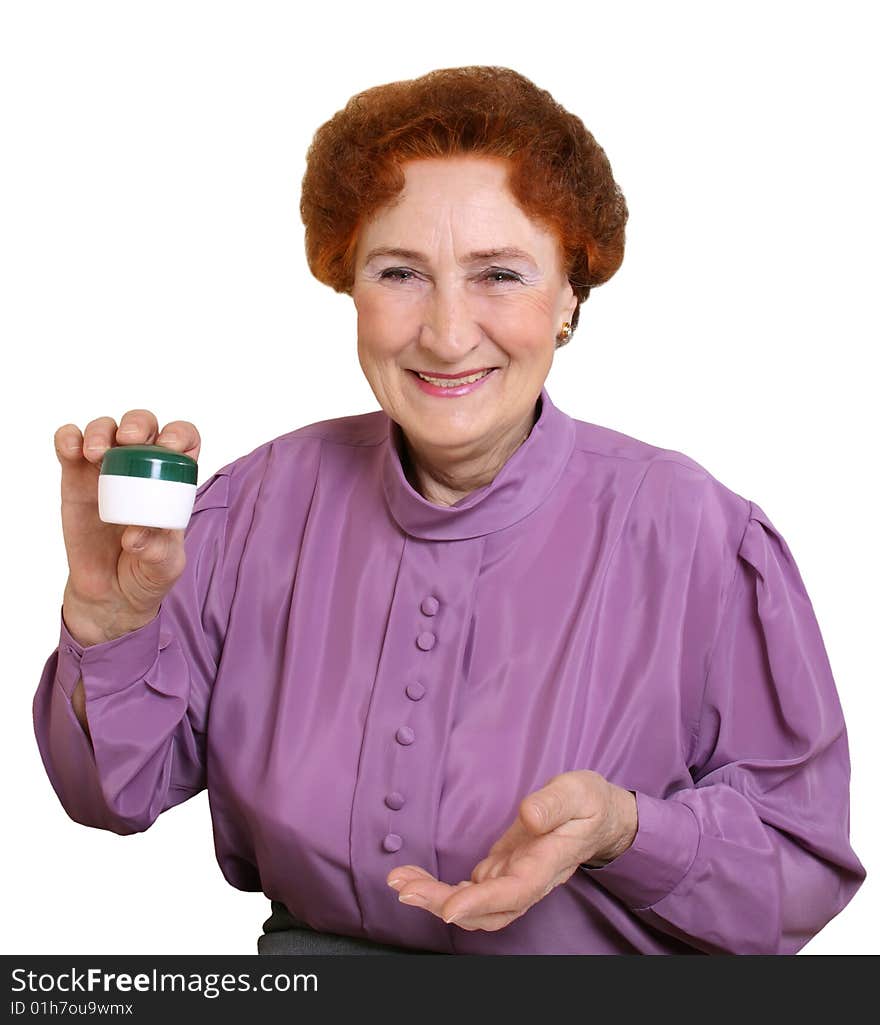 The elderly woman holds in a hand a jar with a cream. The elderly woman holds in a hand a jar with a cream