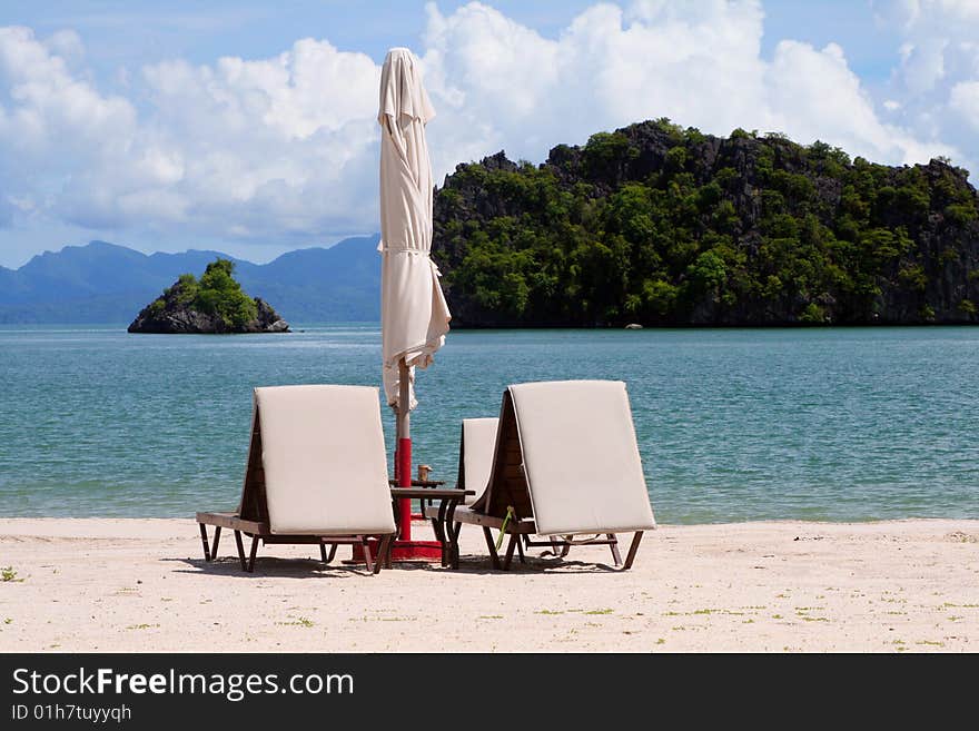 Sunbeds and parasols on a sandy beach in Langkawi, Malaysia. Sunbeds and parasols on a sandy beach in Langkawi, Malaysia