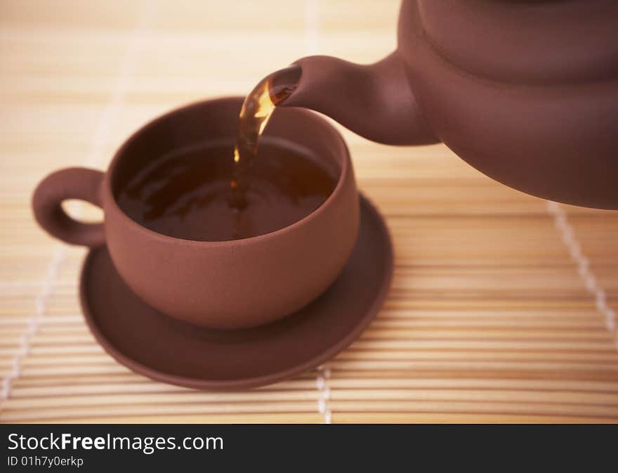 Tea is poured from a teapot into a cup