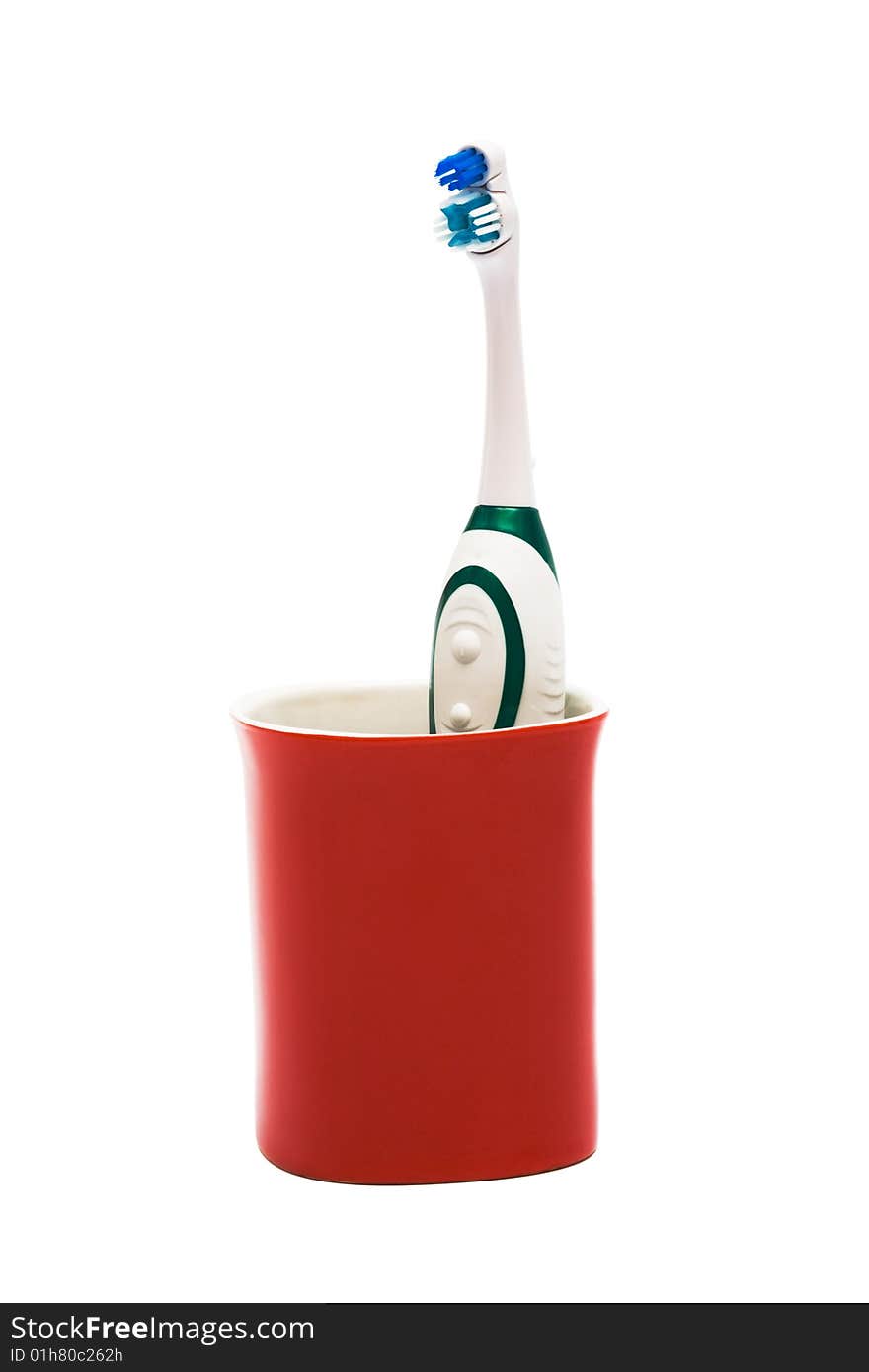 Toothbrush in a red glass on a white background. Toothbrush in a red glass on a white background