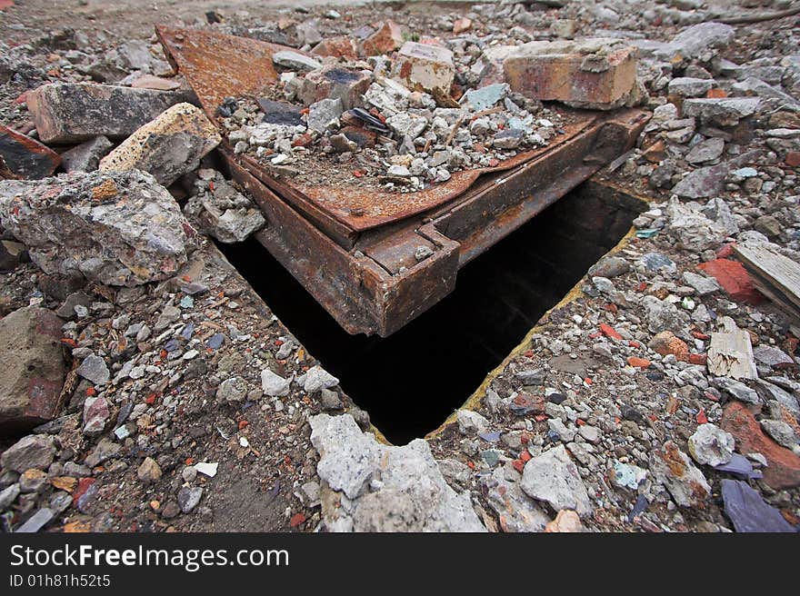 Manhole covered with rubble.