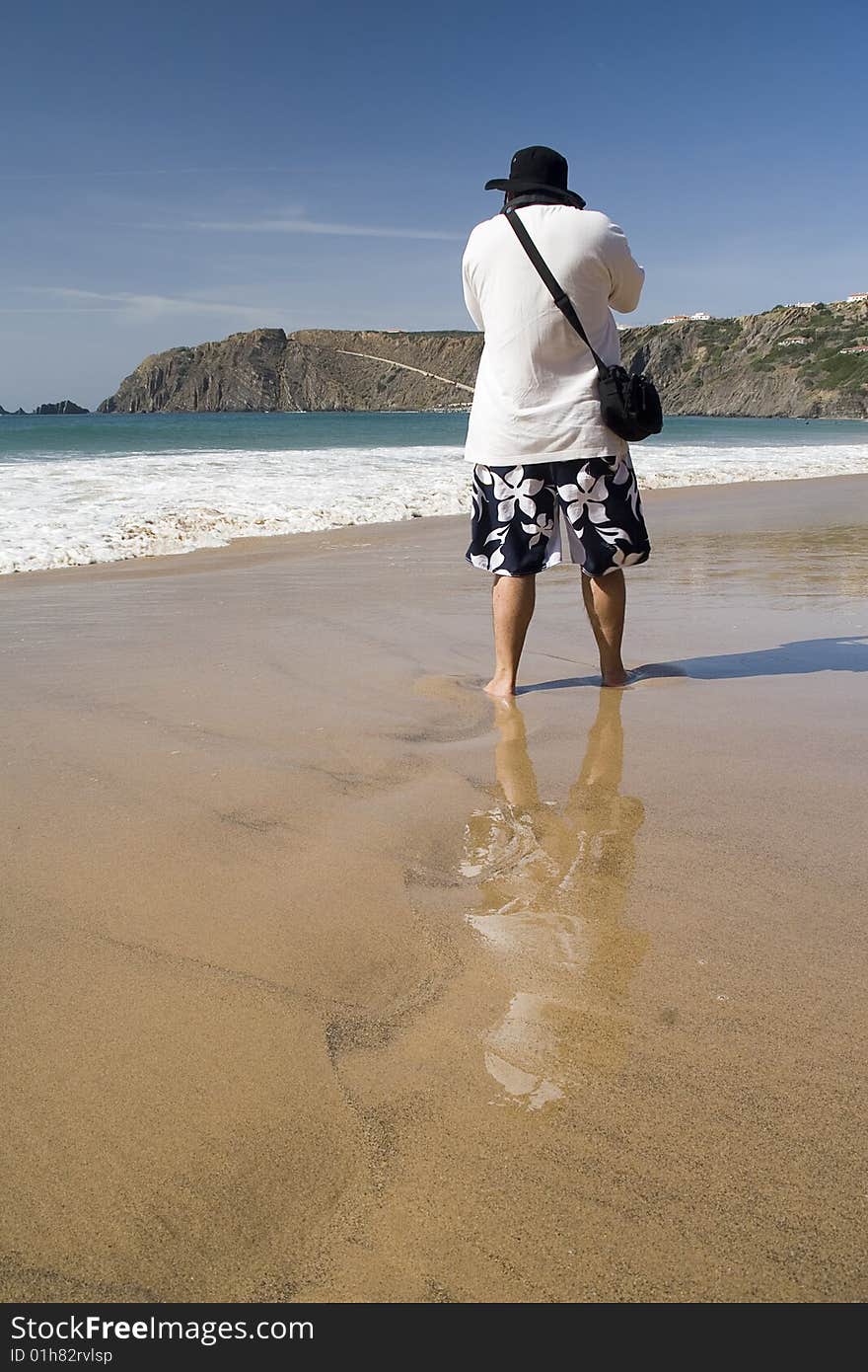 Male photographer on the beach taking a holiday photo