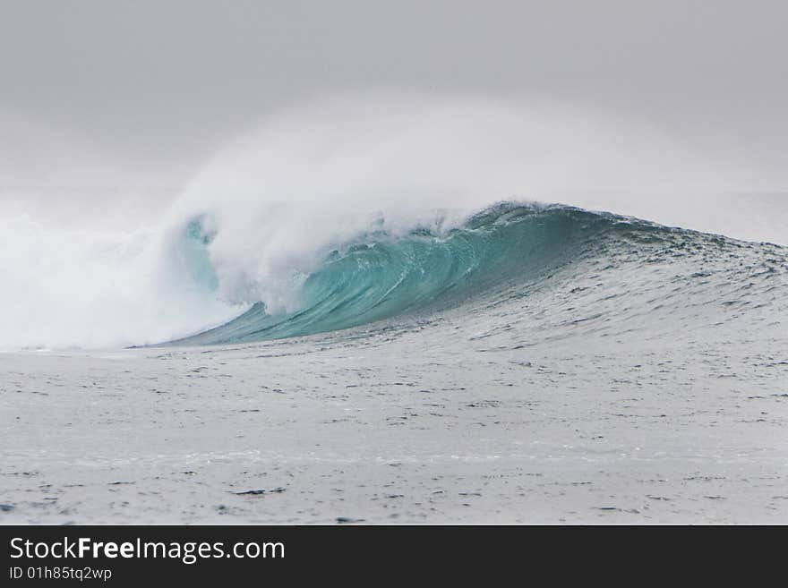 Big wave breaks over a reef