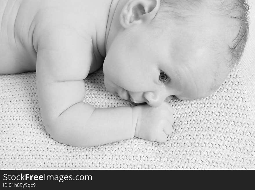 Month old baby boy on a light blanket. Black and White