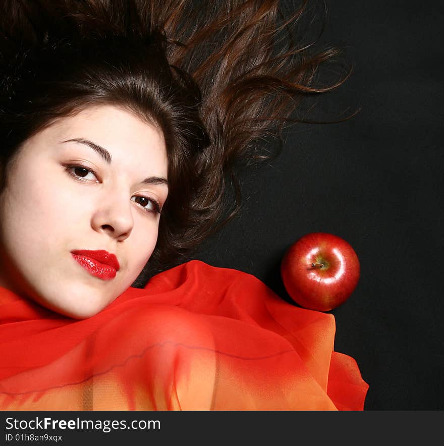 Portrait of the beautiful girl with an apple and developing hair. Portrait of the beautiful girl with an apple and developing hair.