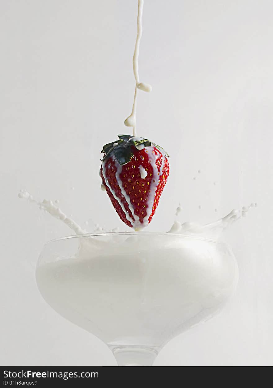 Strawberry falling in the glass of milk. Strawberry falling in the glass of milk