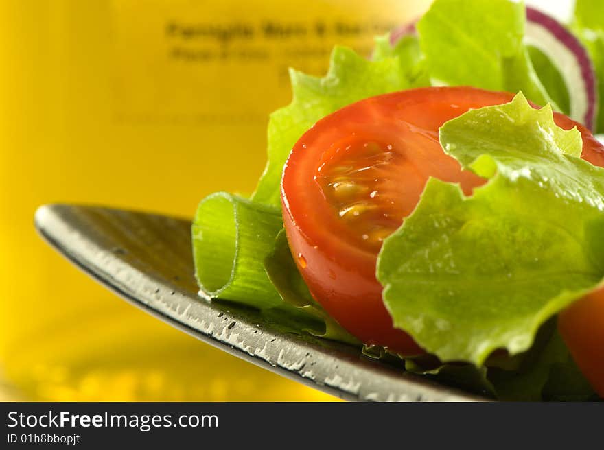 Healthy fresh salad isolated on plate. Bottle of olive oil on background. Healthy lifestyle. Healthy fresh salad isolated on plate. Bottle of olive oil on background. Healthy lifestyle.