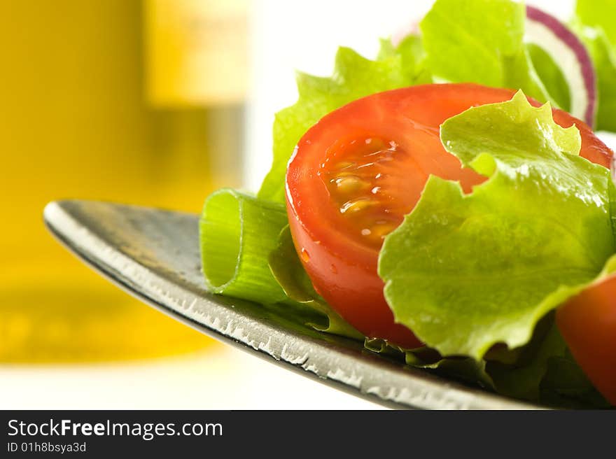 Healthy fresh salad isolated on plate. Bottle of olive oil on background. Healthy lifestyle. Healthy fresh salad isolated on plate. Bottle of olive oil on background. Healthy lifestyle.